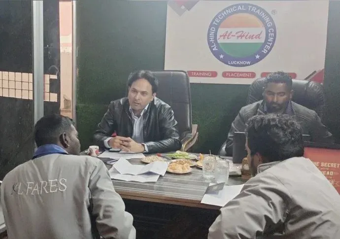Counsellor talking with visitors at a table in a technical training institute office in Ballia