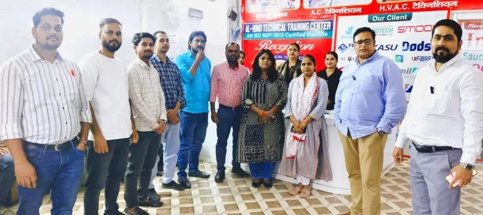 Staff and visitors standing together in front of a banner at Al-Hind Technical Training Center, Ballia